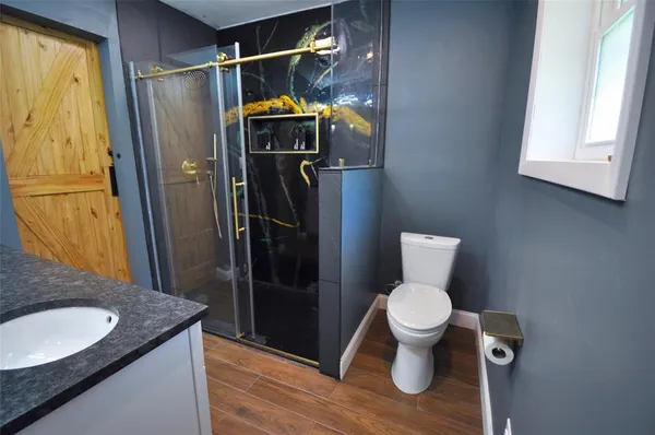 a bathroom with a granite countertop toilet and a sink