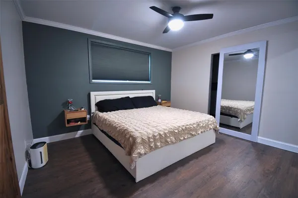 a bedroom with a bed and lamp with wooden floor