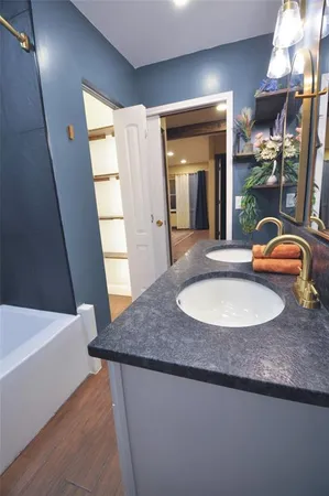a bathroom with a granite countertop sink and a mirror