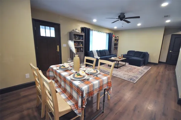 a living room with dining table furniture and a wooden floor