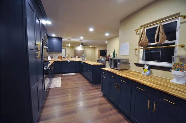 a large kitchen with stainless steel appliances kitchen island granite countertop a large counter top and wooden cabinets