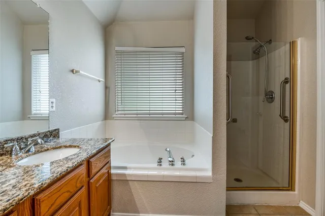 a bathroom with a granite countertop sink a mirror and a shower