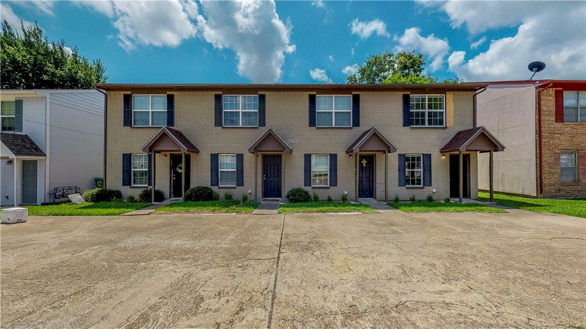 2912 Prairie Flower Circle, Unit D Bryan, TX 77802 - Photo 1 of 22 a front view of a house with a yard and garage