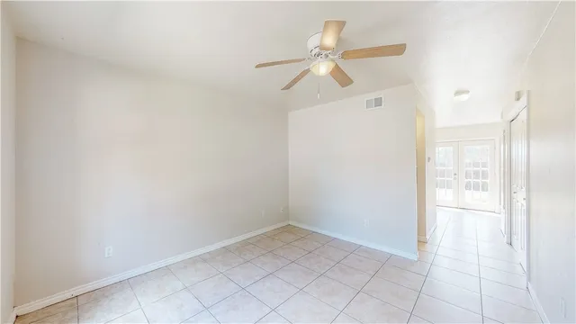 an empty room with windows and fan