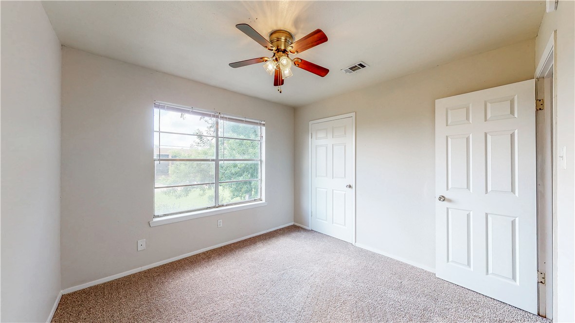 2912 Prairie Flower Circle, Unit D Bryan, TX 77802 - Photo 10 of 22 an empty room with ceiling fan and windows