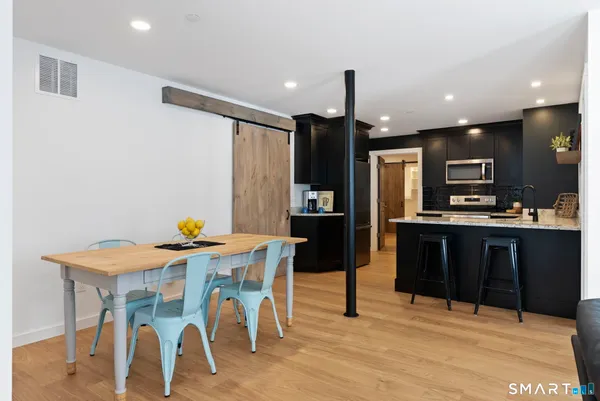 a kitchen with stainless steel appliances kitchen island granite countertop a refrigerator and a stove top oven