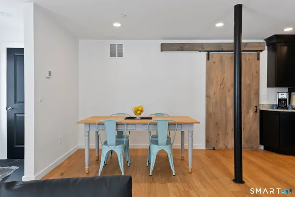 a view of a dining room with furniture wooden floor kitchen and a chandelier
