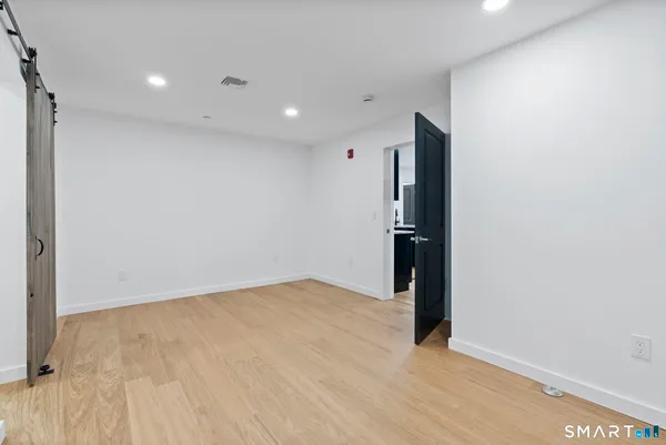 a view of a room with wooden floor and white walls