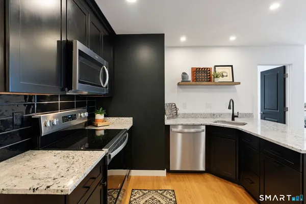 a kitchen with stainless steel appliances granite countertop a sink stove and microwave