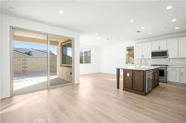 a large kitchen with stainless steel appliances granite countertop a stove a sink and a refrigerator