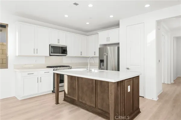 a kitchen with a sink a stove a refrigerator a center island and a window