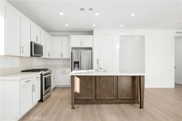 a kitchen with kitchen island granite countertop a sink and stove top oven