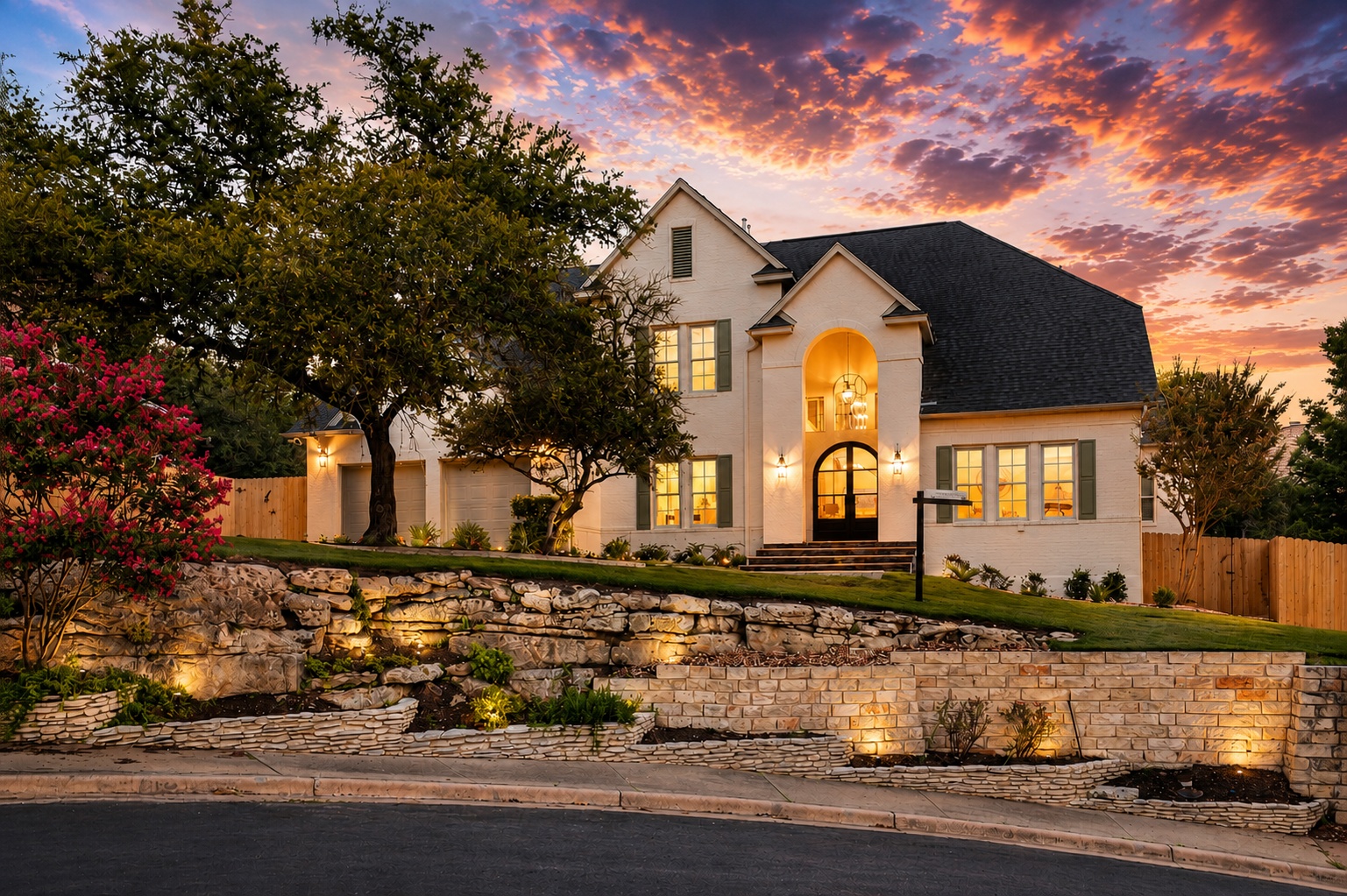6905 Rudi Cove Austin, TX 78759 - Photo 2 of 37 An inviting exterior with a brick and stone facade and mature trees under a dramatic evening sky.