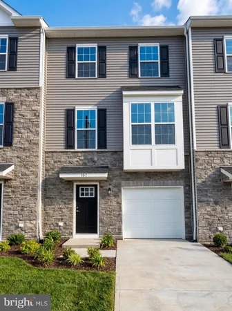 a front view of a house with yard and parking