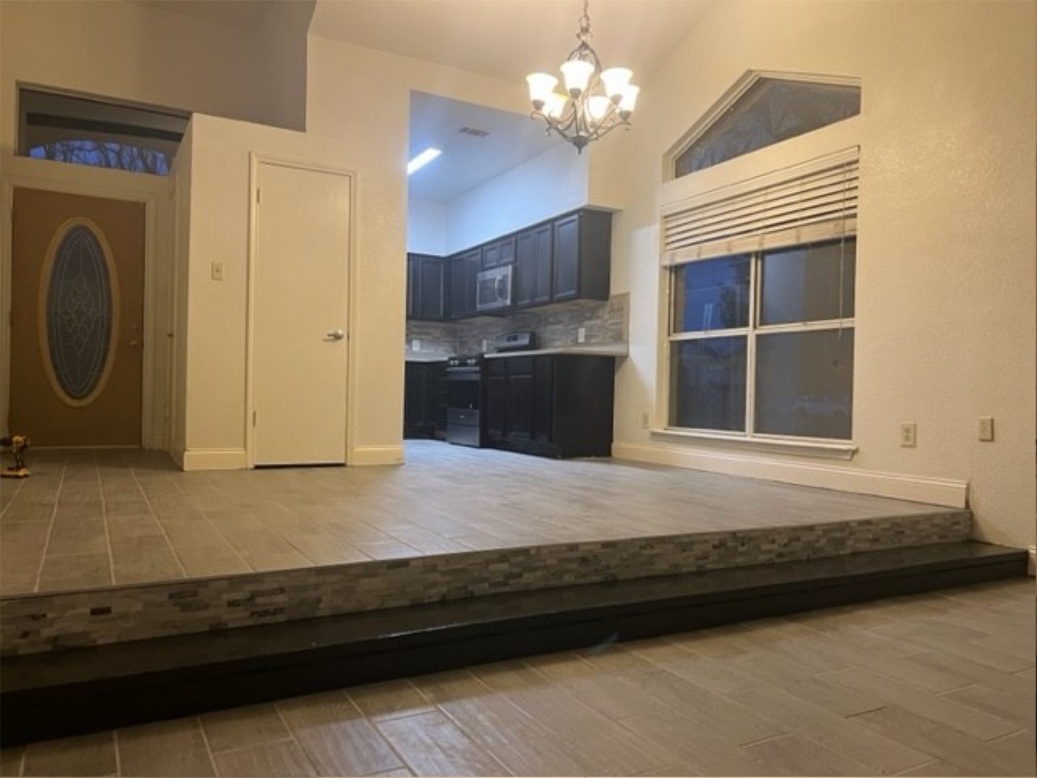 5611 Meadow Crest Austin, TX 78744 - Photo 11 of 29 A split-level interior with soaring vaulted ceilings, featuring an inviting entrance and a sleek kitchen.