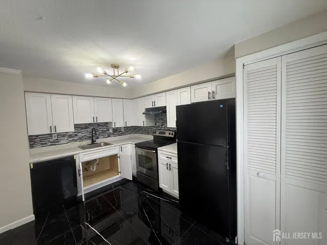 a kitchen with a refrigerator and a stove top oven