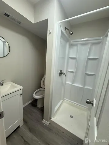 a bathroom with a granite countertop sink toilet and shower