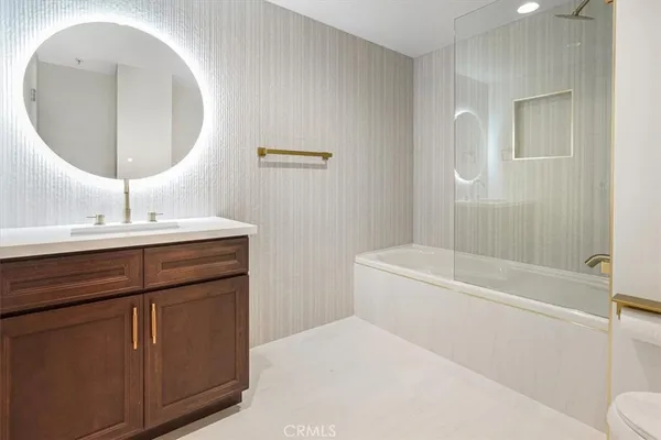 a bathroom with a tub a sink and a mirror