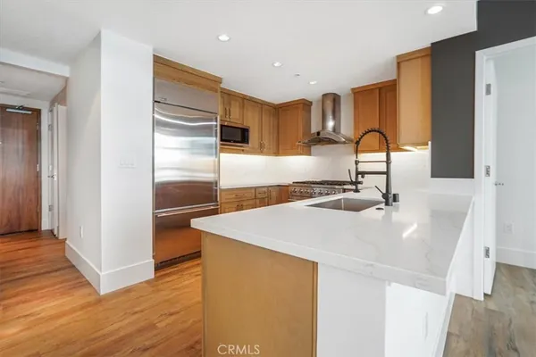 a kitchen with stainless steel appliances granite countertop a sink and a refrigerator