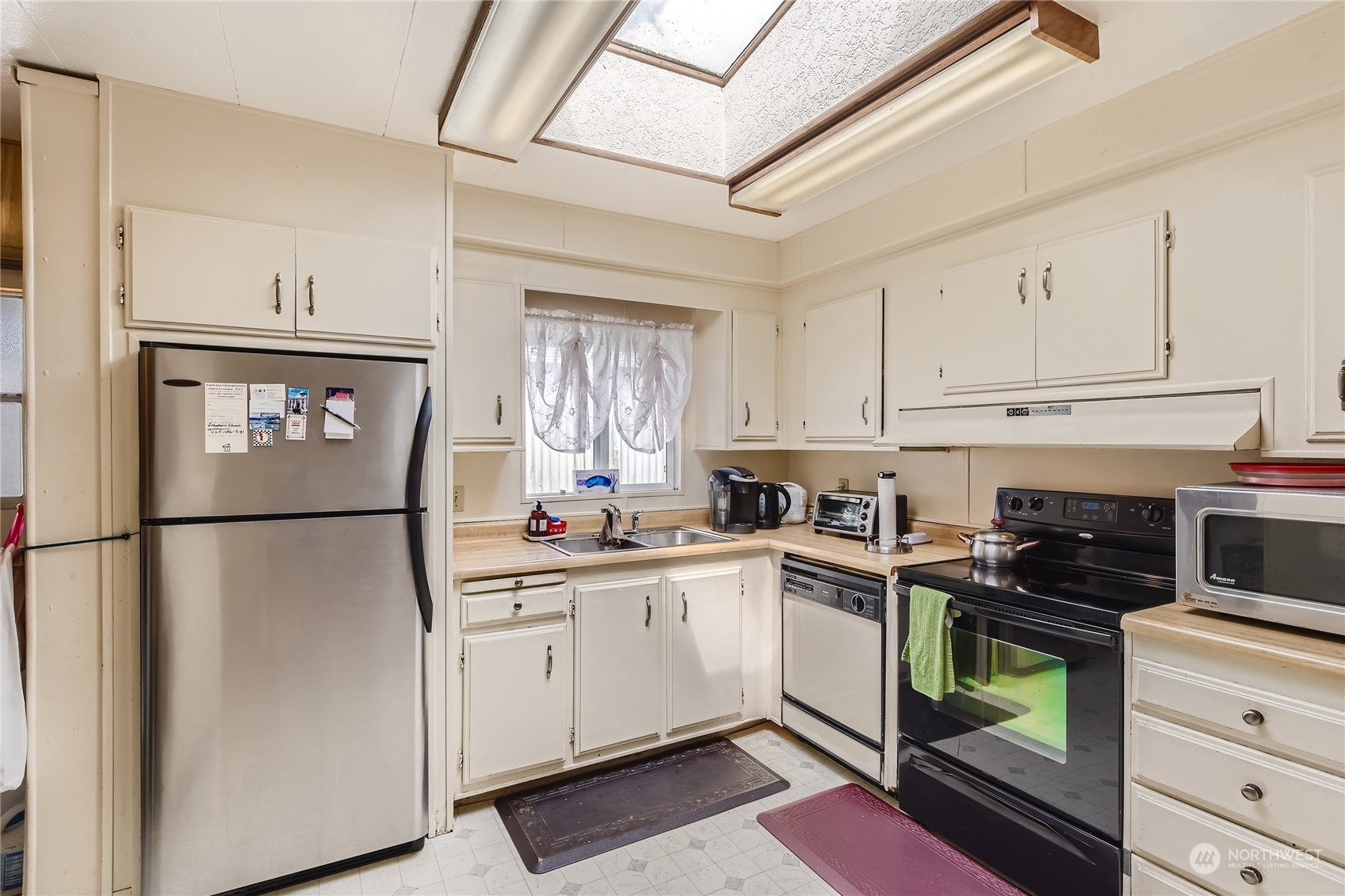 1121 244th Street Southwest, Unit 50 Bothell, WA 98021 - Photo 7 of 22 a kitchen with white cabinets and white appliances