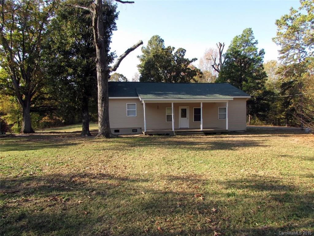 a view of a house with a yard and tree s