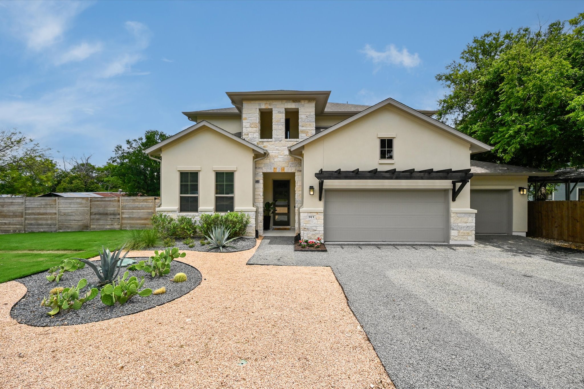 913 Presa Arriba Road Austin, TX 78733 - Photo 1 of 30 Architectural stone accents elevate this desert-inspired residence with an inviting front entry and dual garages.
