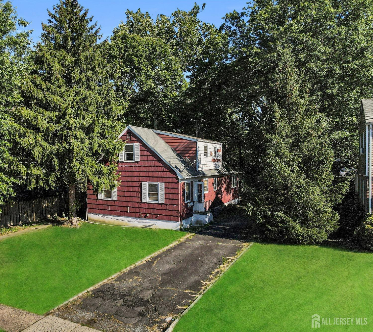 a view of house with a big yard potted plants and large tree