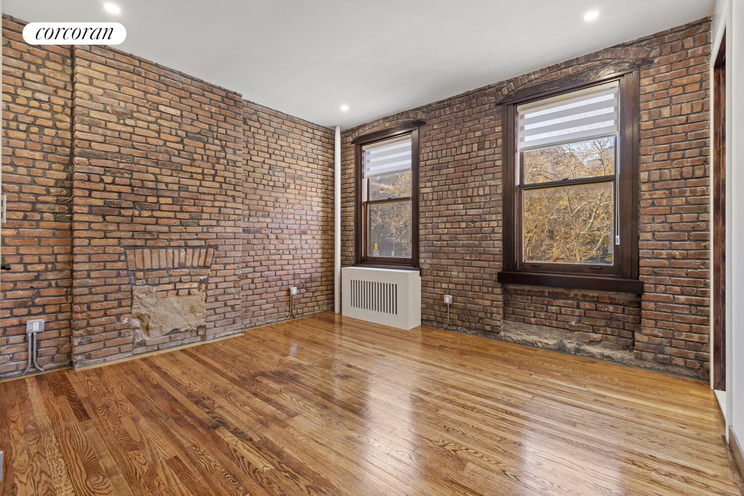 154 9th Avenue Manhattan, NY 10011 - Photo 10 of 11 a view of an empty room with wooden floor and a window