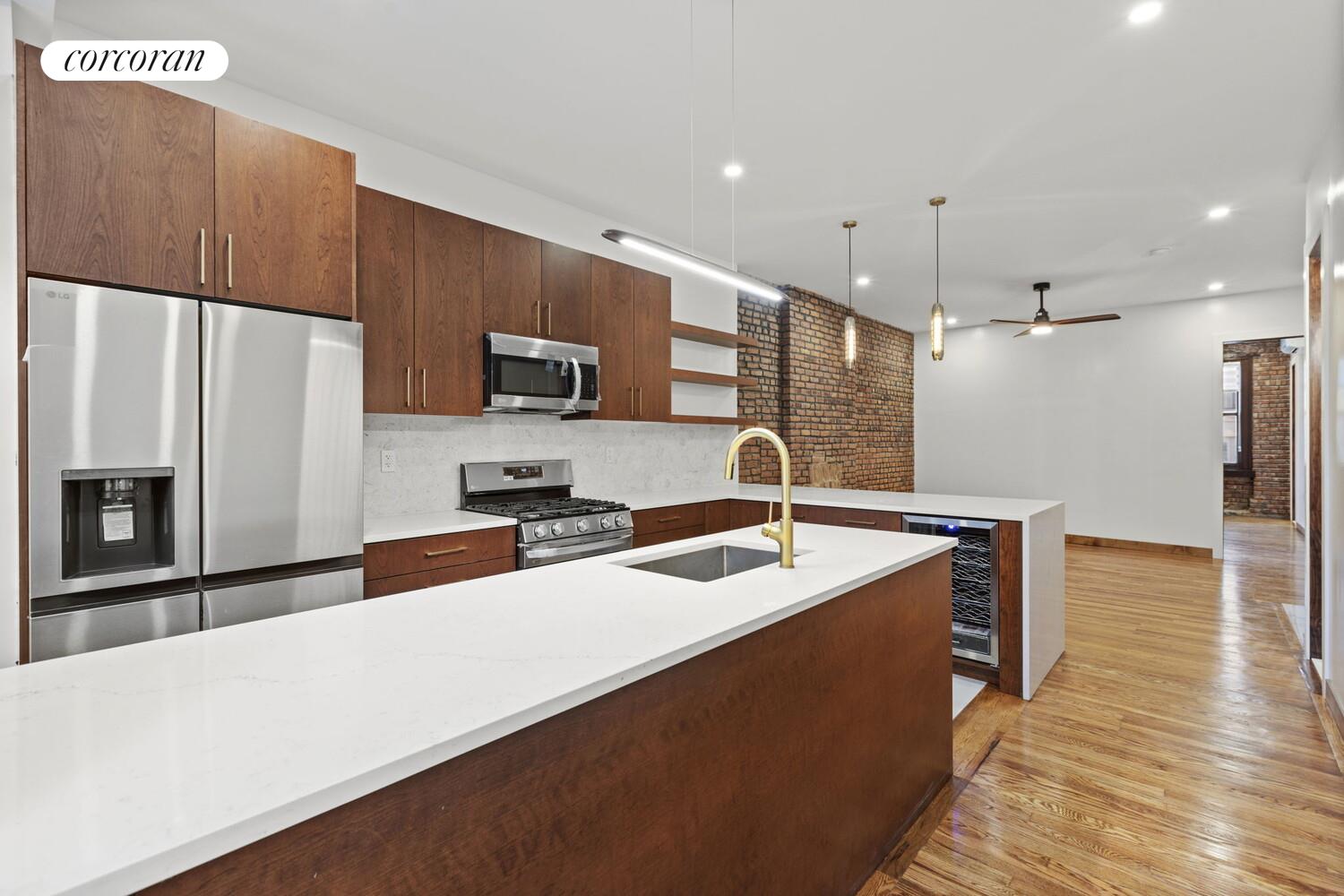 154 9th Avenue Manhattan, NY 10011 - Photo 8 of 11 a kitchen with stainless steel appliances a sink a stove a microwave and a refrigerator