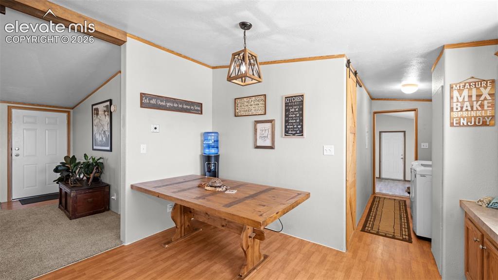 33975 Highway 94 Yoder, CO 80864 - Photo 10 of 40 Open-concept dining area featuring wood-finish flooring, a rustic wood table, and a contemporary light fixture