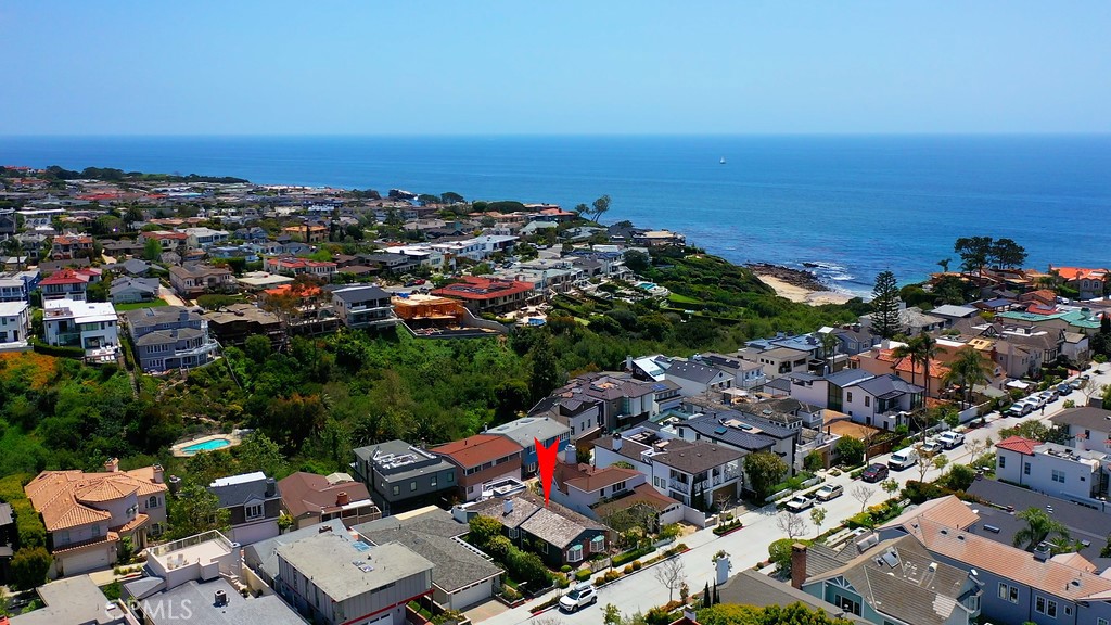 an aerial view of a city with ocean view in back