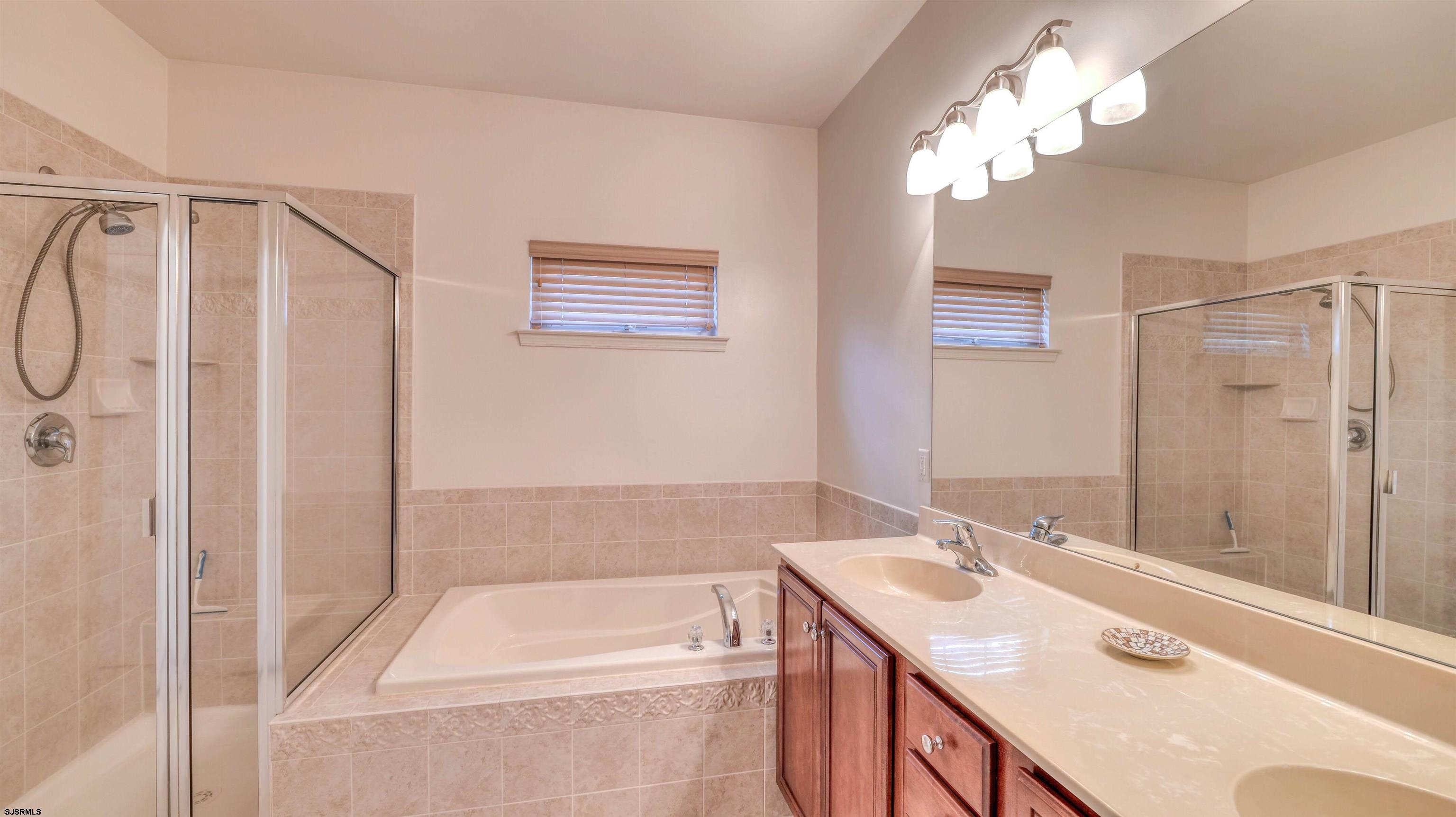 212 Lander Road Egg Harbor Township, NJ 08234 - Photo 18 of 33 a bathroom with a tub a sink and mirror