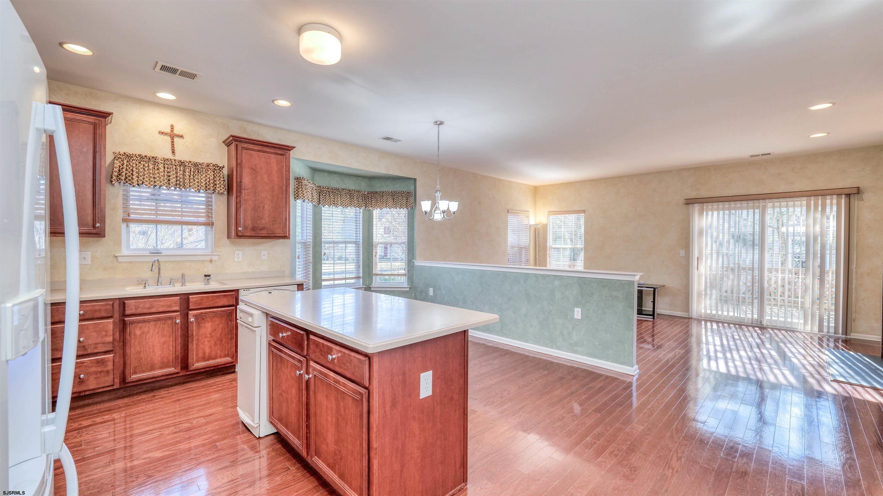 212 Lander Road Egg Harbor Township, NJ 08234 - Photo 9 of 33 a kitchen with stainless steel appliances granite countertop a sink a stove a refrigerator cabinets and wooden floors