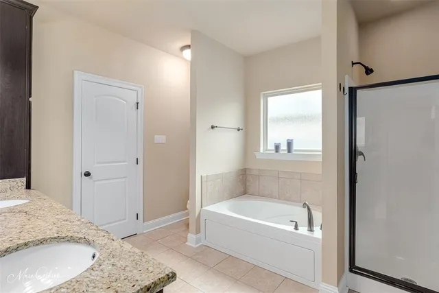 a bathroom with a granite countertop tub sink and a mirror