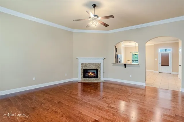 an empty room with fireplace and wooden floor