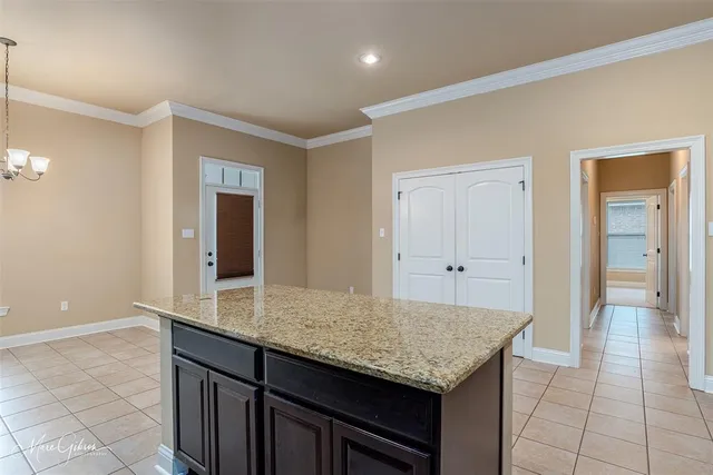 a kitchen with granite countertop a sink and white cabinets