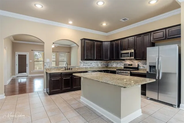 a kitchen with stainless steel appliances granite countertop a stove sink and refrigerator