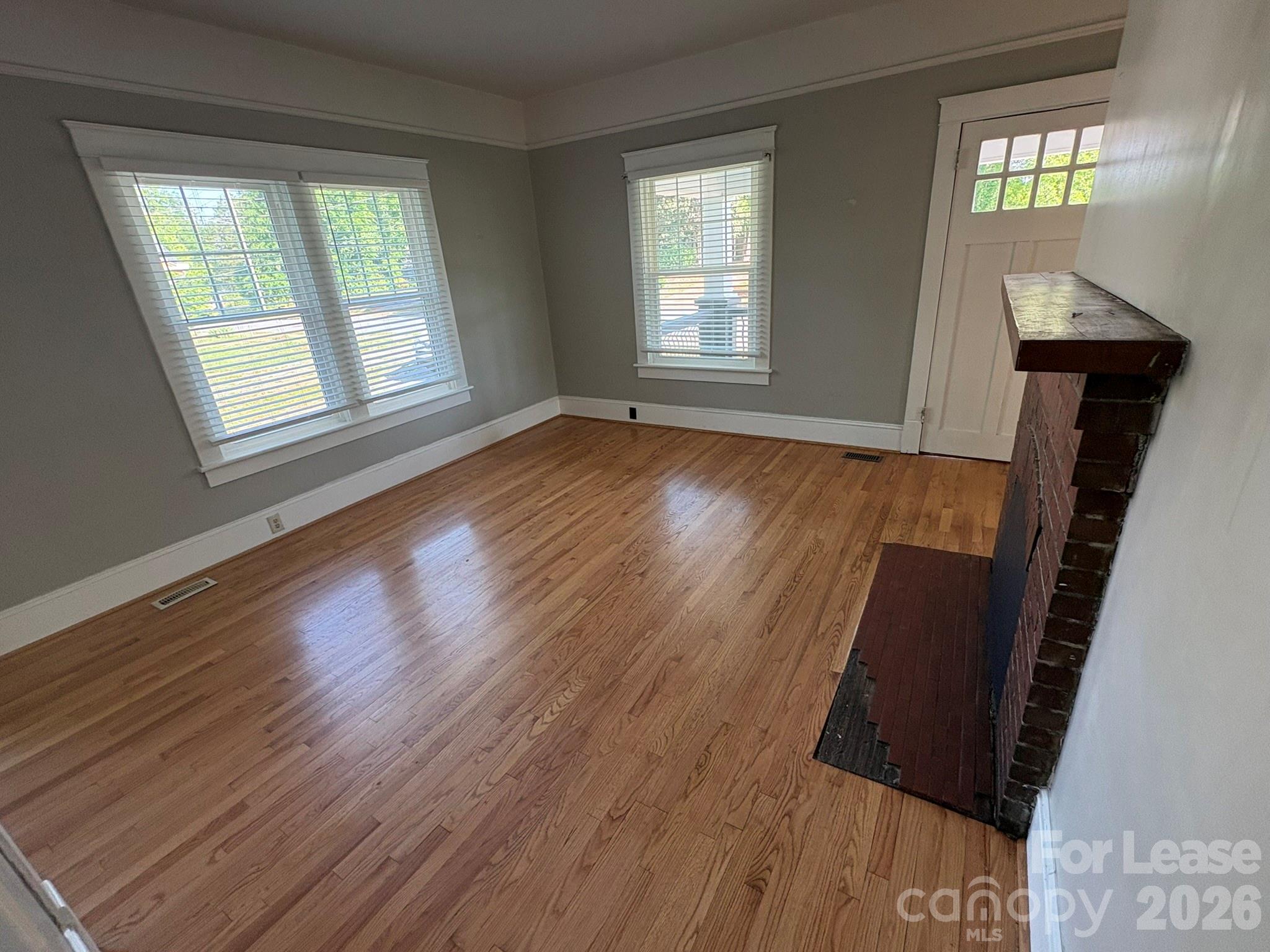 303 Bouchelle Street Morganton, NC 28655 - Photo 5 of 12 a view of an empty room with wooden floor and a window