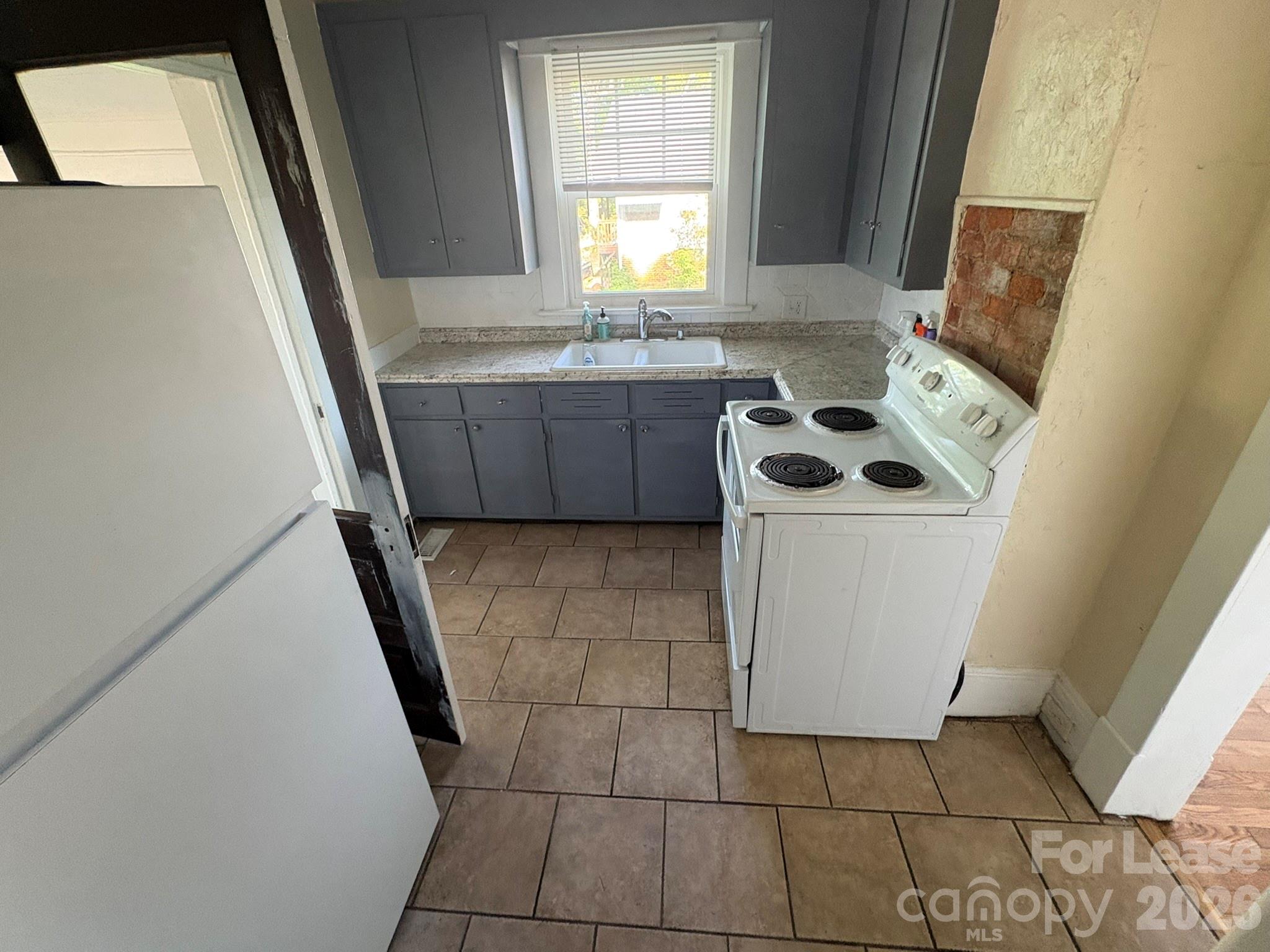 303 Bouchelle Street Morganton, NC 28655 - Photo 9 of 12 a bathroom with a sink a toilet a mirror and a window
