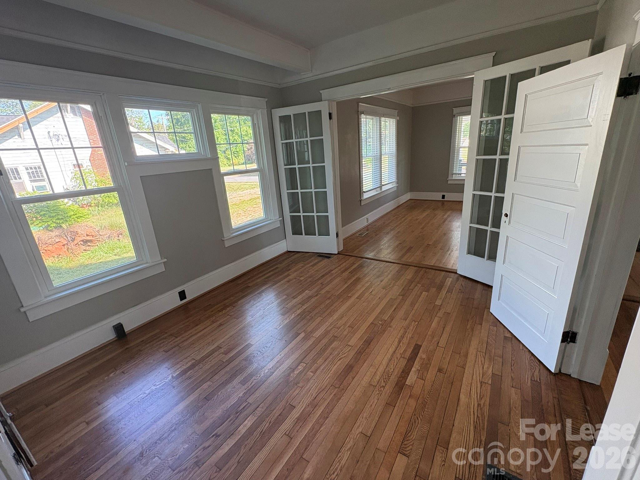 303 Bouchelle Street Morganton, NC 28655 - Photo 10 of 12 wooden floor in an empty room with a window