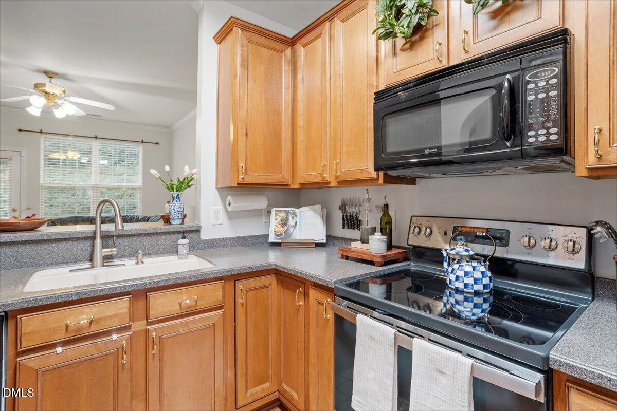 5349 Silver Moon Lane Raleigh, NC 27606 - Photo 14 of 41 a kitchen with stainless steel appliances granite countertop a sink stove and microwave