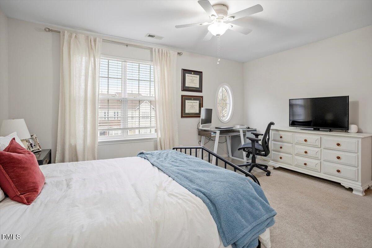 5349 Silver Moon Lane Raleigh, NC 27606 - Photo 22 of 41 a bedroom with a bed and a flat screen tv