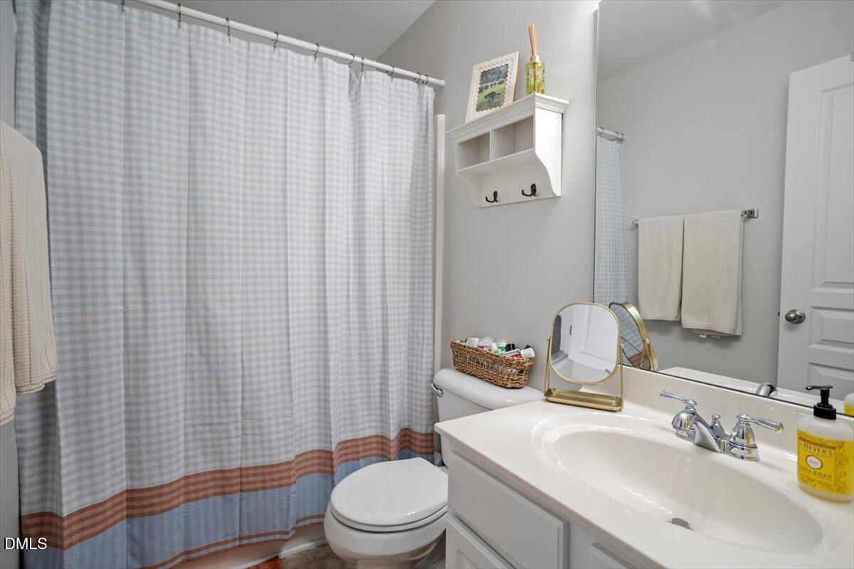 5349 Silver Moon Lane Raleigh, NC 27606 - Photo 24 of 41 a bathroom with a sink a toilet and shower curtain