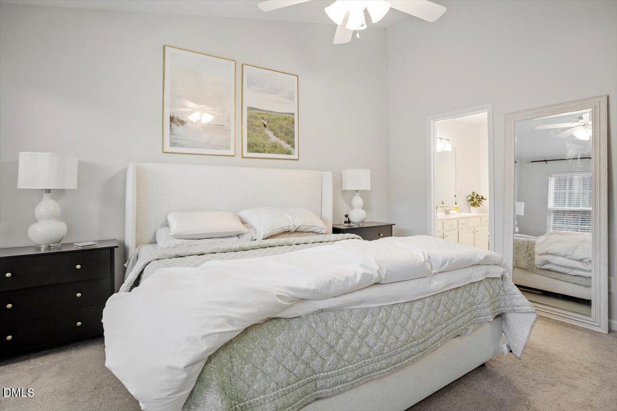 5349 Silver Moon Lane Raleigh, NC 27606 - Photo 28 of 41 a bedroom with a bed and a chandelier