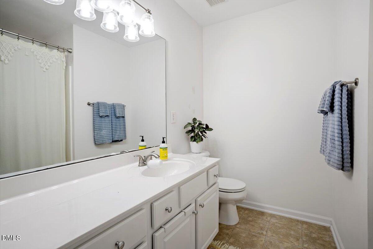 5349 Silver Moon Lane Raleigh, NC 27606 - Photo 29 of 41 a bathroom with a sink a toilet and shower curtain