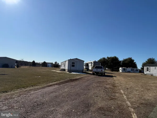 a view of a dirt road with a building in the background