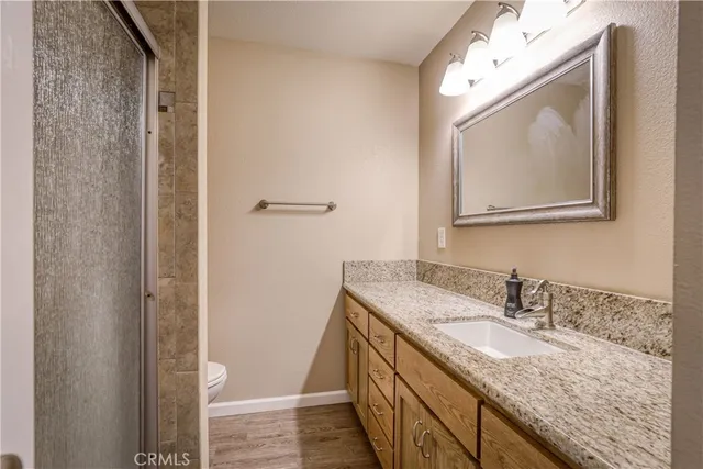 a bathroom with a granite countertop sink vanity and mirror