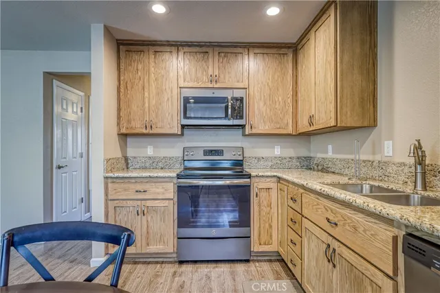 a kitchen with granite countertop wooden cabinets and white appliances