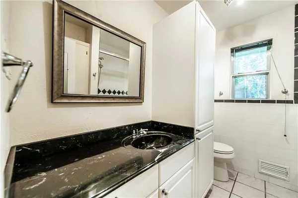 a bathroom with a sink a toilet a mirror and shower
