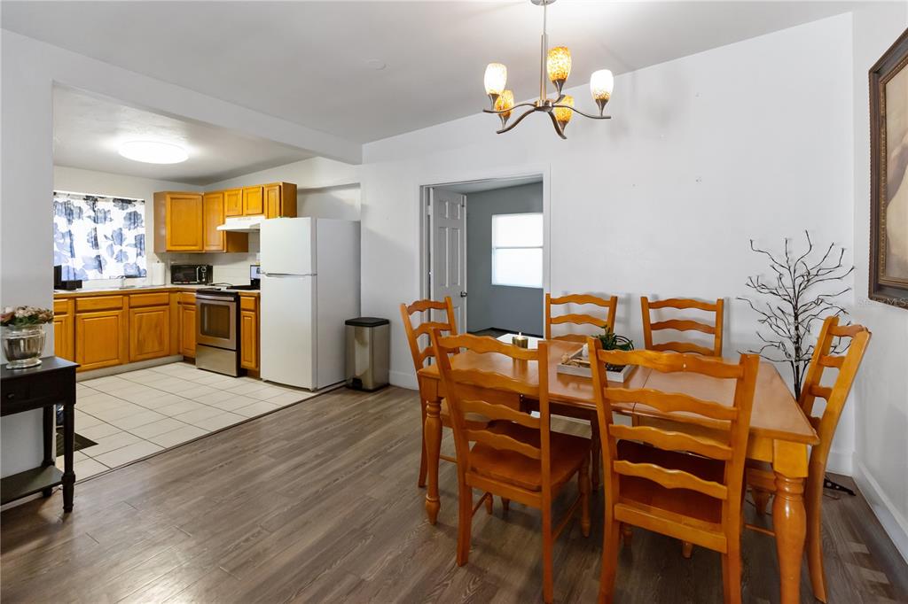 4303 Anderson Road Orlando, FL 32812 - Photo 11 of 47 a view of a dining room with furniture a kitchen and chandelier